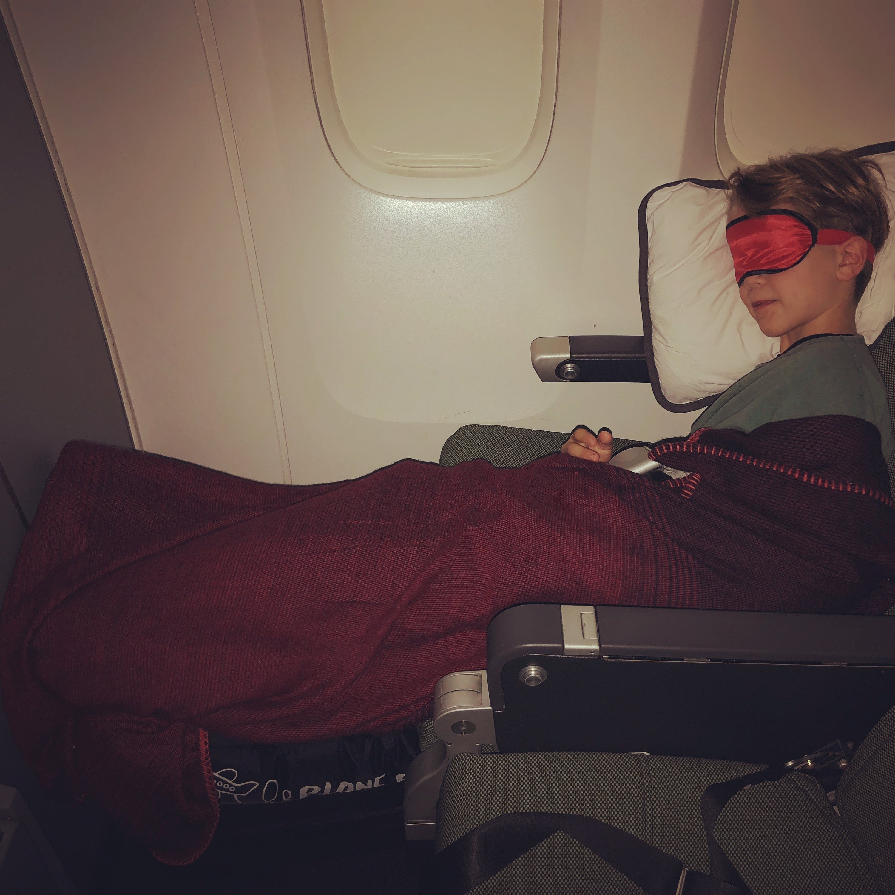 Sam's son sleeping on a Qantas flight with Plane Pal, 2018